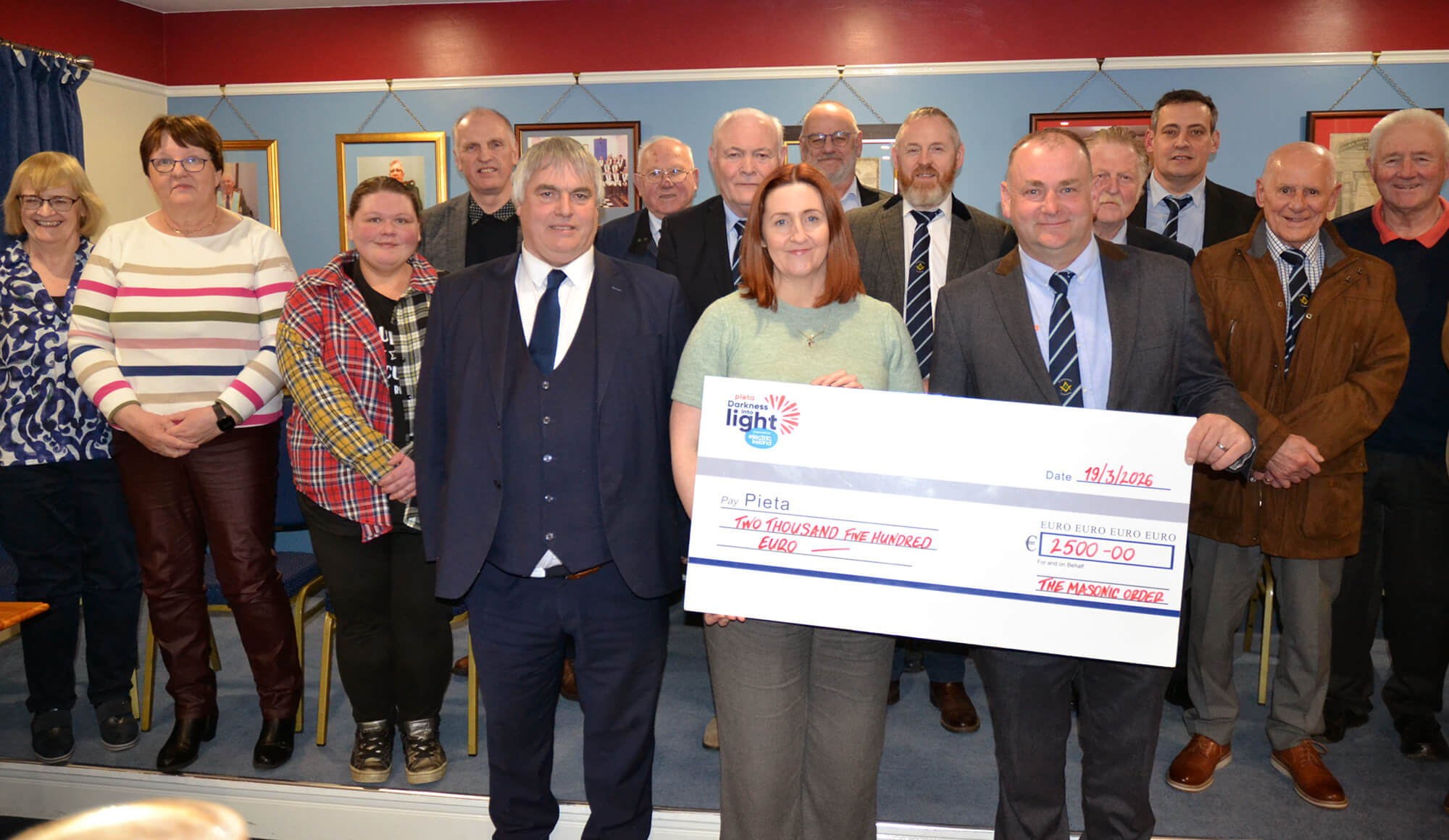 Worshipful Master Nigel Buchanan of Lodge 281 St Johnston presents a €2,500 cheque to Paula Coyle of Pieta, surrounded by members of the Masonic Order, 19 March 2026